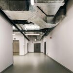 Spacious industrial hallway featuring exposed HVAC ductwork and modern design elements.