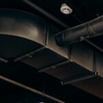 Detailed view of industrial air ducts on a ceiling, showcasing modern urban design.